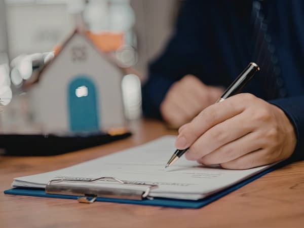 Hombre firmando un contrato que cumple la Ley de Arrendamientos Urbanos