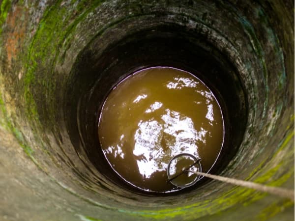 cubo recogiendo agua demostrando cuanto cuesta hacer un pozo