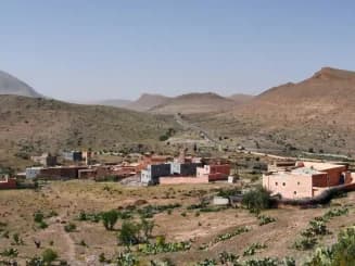 Aldeia em zona montanhosa com habitações dispersas, exemplo de como é possível construir em terreno rústico.