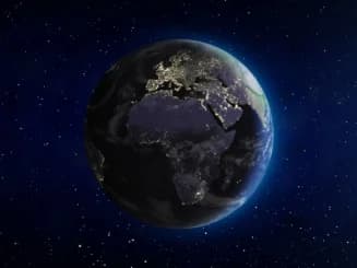 magen de la Tierra vista desde el espacio, mostrando Europa y el continente africano iluminados por las luces de las ciudades, con un fondo estrellado.