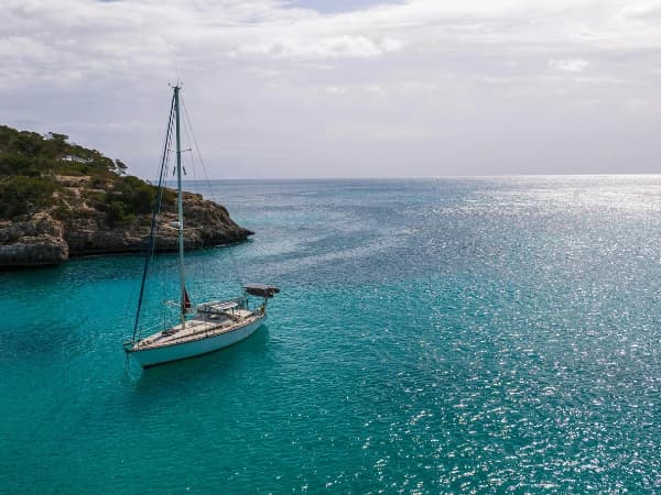 Barco velero en la playa de uno de los mejores pueblos cerca de Palma de Mallorca para vivir