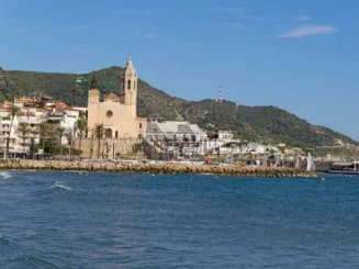 Dique con iglesia de fondo en uno de los pueblos cerca de Barcelona para vivir