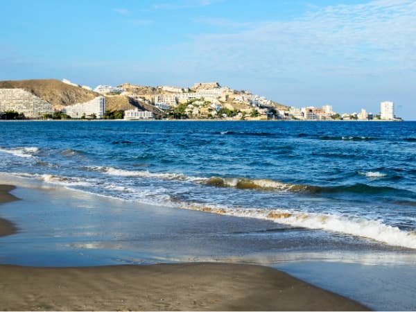 playa con hoteles de fondo de uno de los mejores pueblos cerca de Valencia para vivir