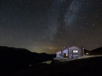 Casa rural iluminada en medio de la noche, como ejemplo de que se puede poner luz en terreno no urbanizable.