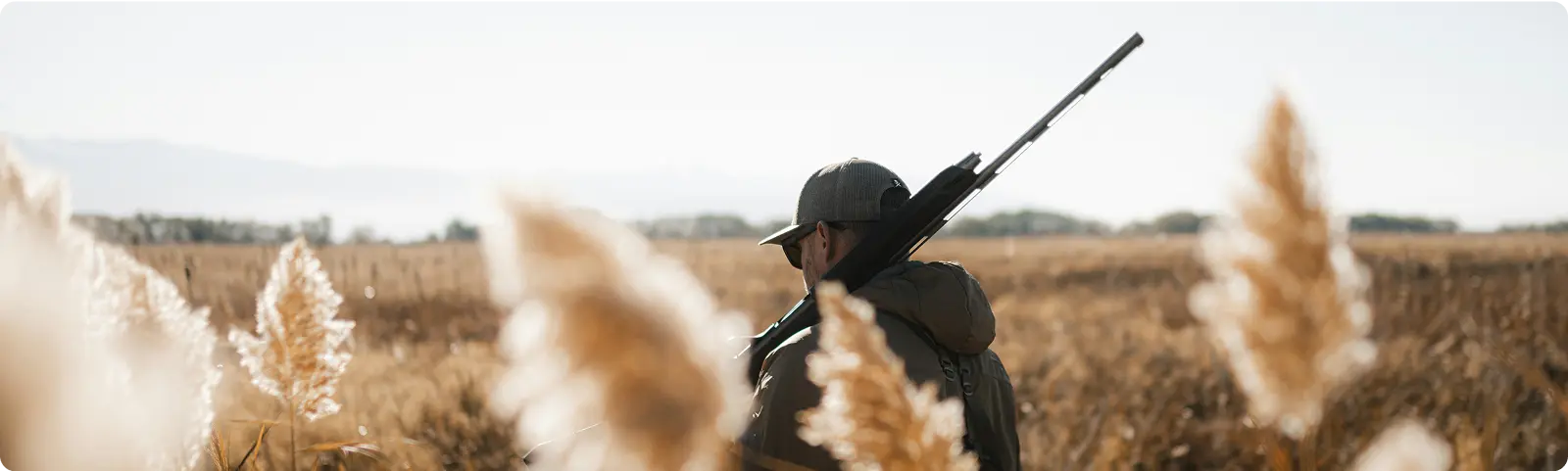 Cazador preparado en el campo con su arma.