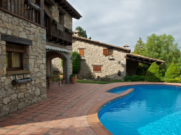 Casa rural de piedra con piscina y jardín, perfecta para turismo rural.