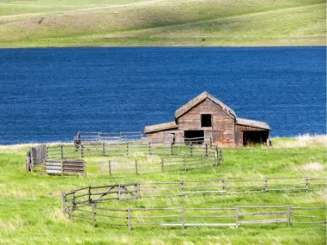 Terreno com uma edificação e um lago ao fundo.