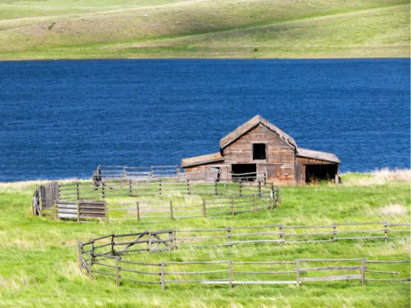 Terreno com uma edificação e um lago ao fundo.