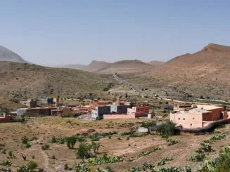 Aldeia em zona montanhosa com habitações dispersas, exemplo de como é possível construir em terreno rústico.