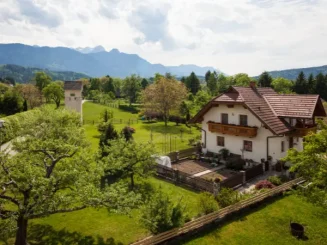 Casa rural com montanhas ao fundo.