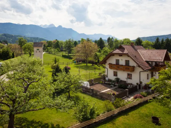 Casa rural com montanhas ao fundo.